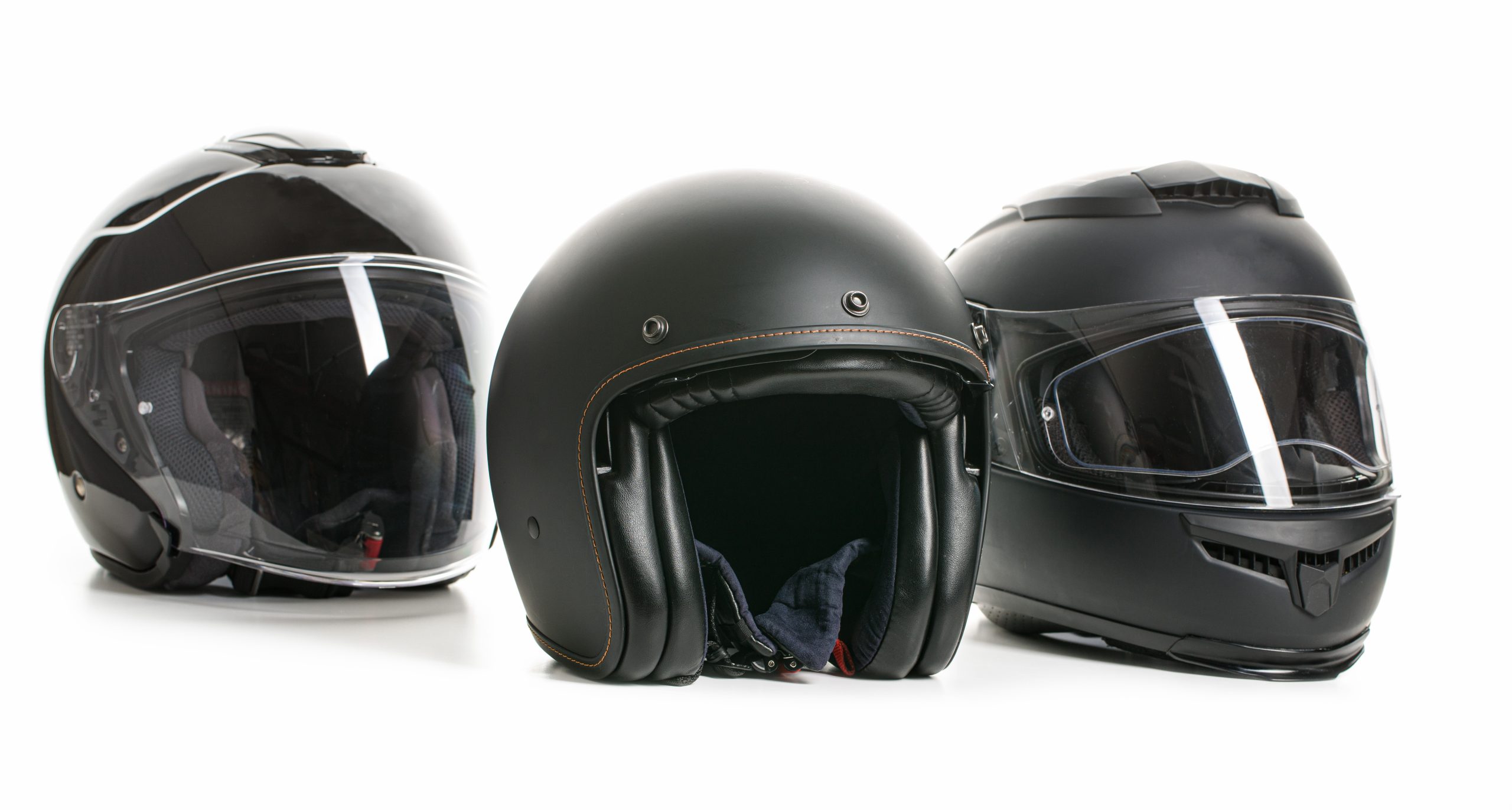 three black motorcycle helmets on a white table