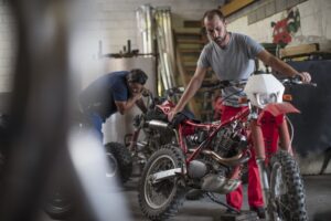 Two mechanics in motorcycle workshop