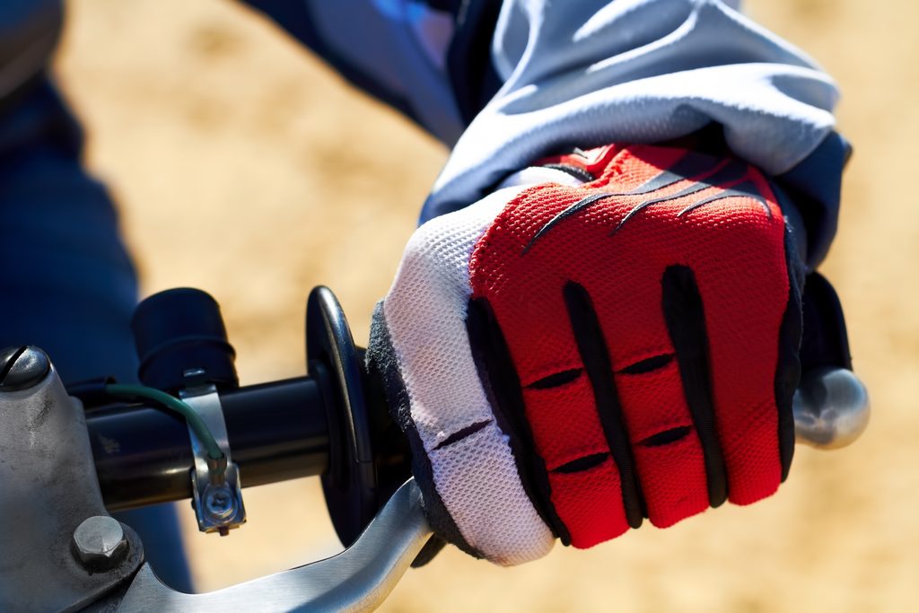Protection for the hands is essential in enduro. Closeup of a dirt bikers hand 