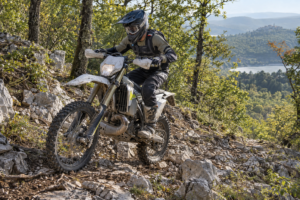 Enduro rider using clutch control to maintain grip on a rocky climb